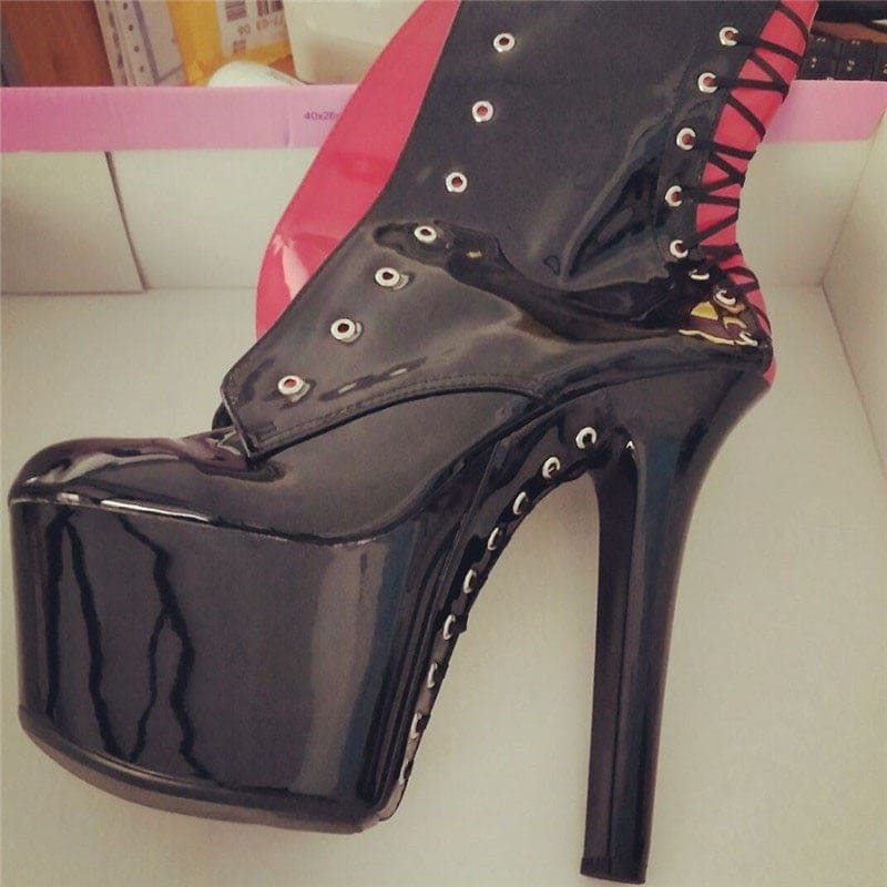 Black patent leather platform stiletto boot with lace-up detail and metal eyelets.