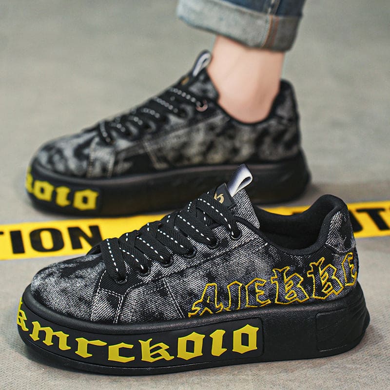 Black and yellow sneakers with gothic-style lettering on the sides.