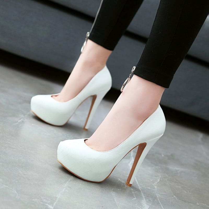 White high-heeled platform pumps with stiletto heels.