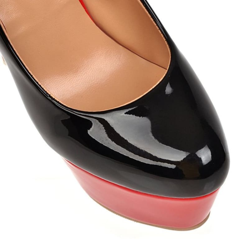 High-heeled shoe with a black patent leather upper and red platform sole.