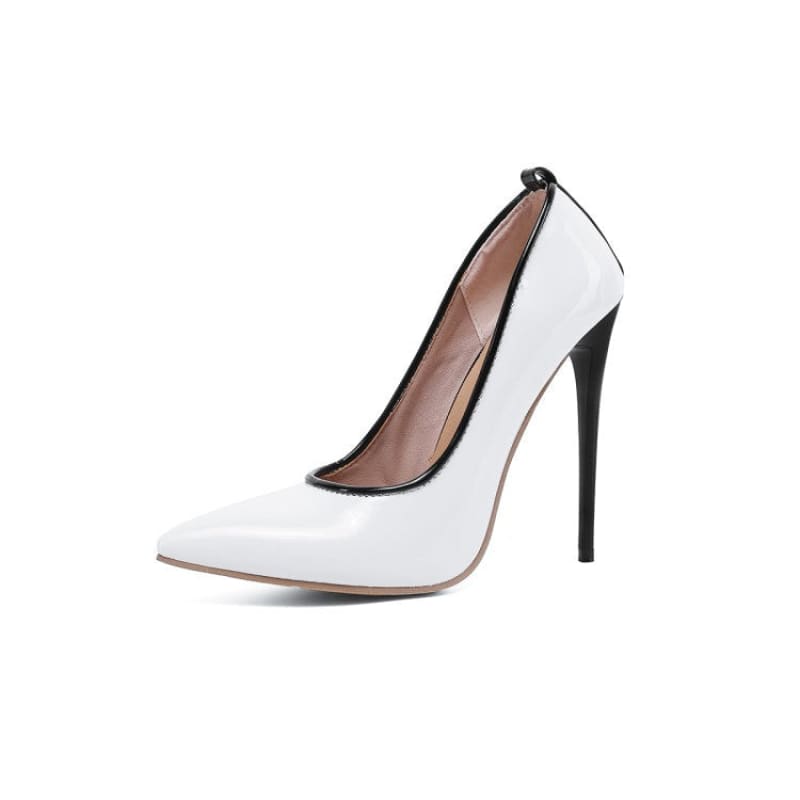White high-heeled pump with a pointed toe and black trim.