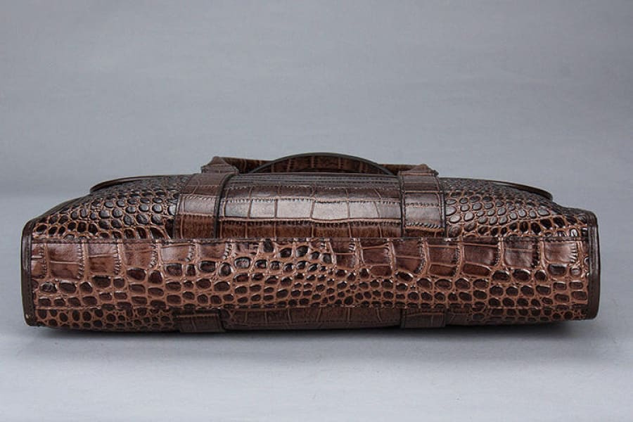 Brown crocodile leather briefcase with textured scales and a handle.