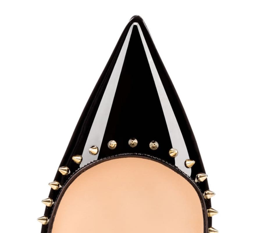 Pointed black shoe toe with gold studs along the edge.