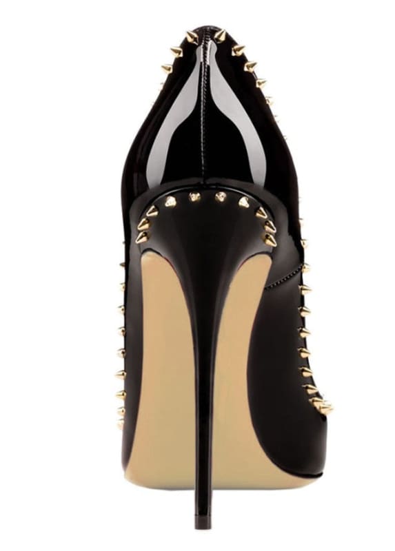 Black patent leather high heel shoe with gold spike studs along the edges.